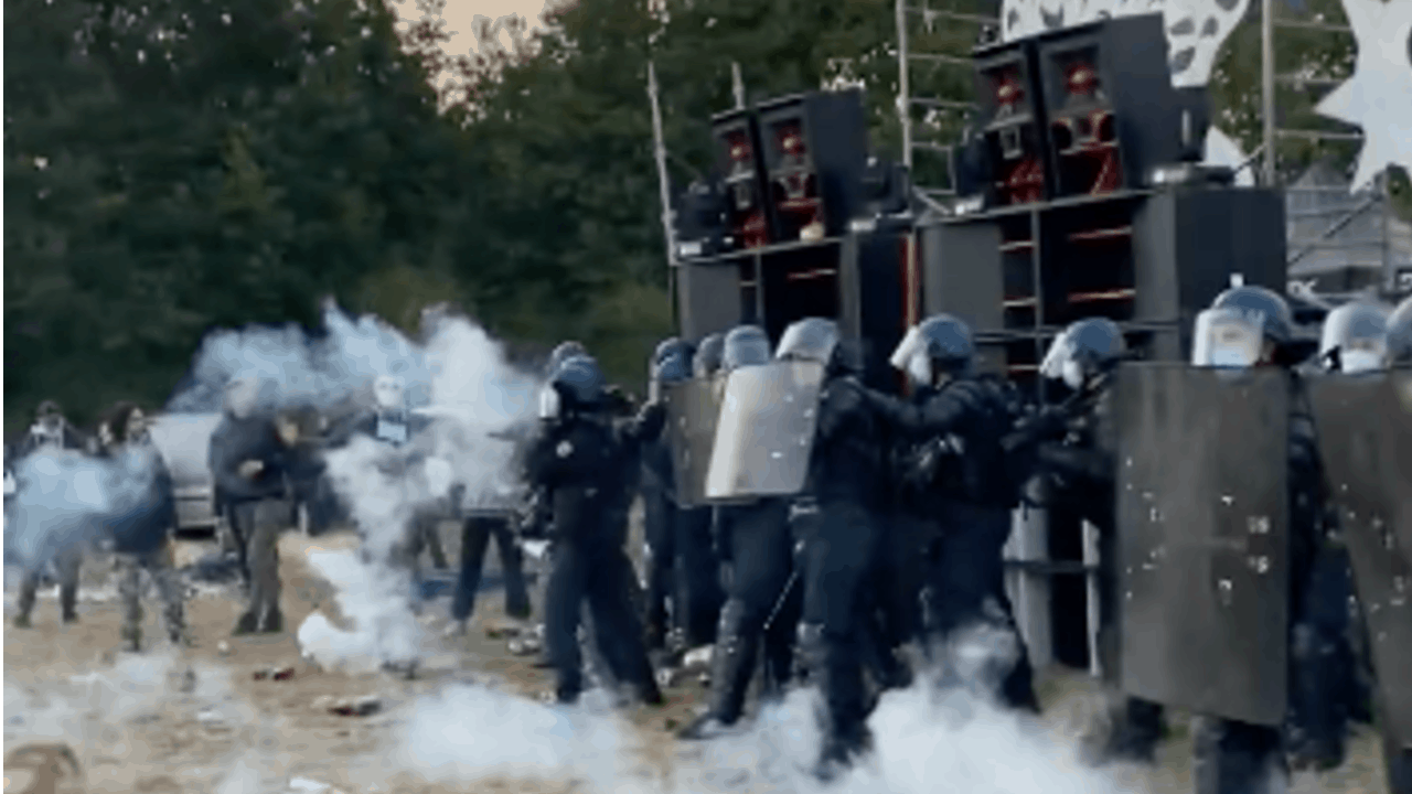 Police in riot gear deploying tear gas while dispersing a free party hosted by Teknoseed, 510 BpM Sound System, Systeme Nerveux and Vikings.